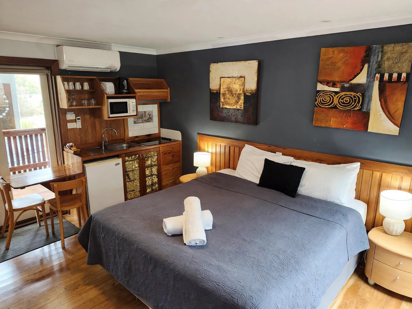 King family room with a large bed, single bed and kitchenette — enhanced sample photo