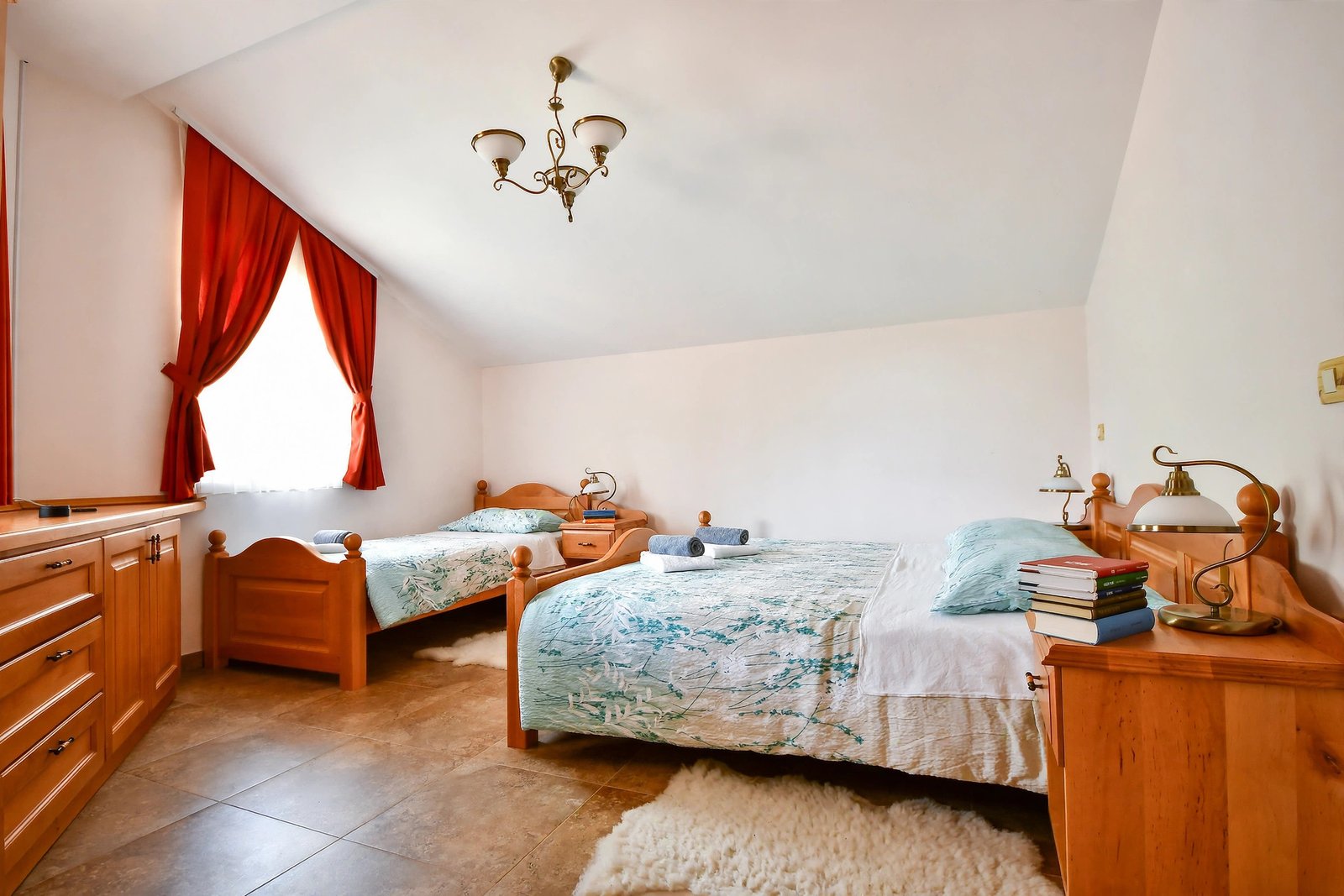 Twin room with two wooden beds and red curtains — enhanced sample photo